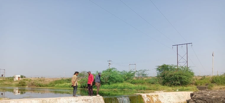 A renovated check dam at Bhadva, water running over the spillway