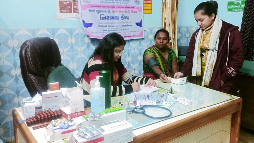 ગામના આરોગ્ય કેમ્પમાં મહિલા સાથે પરામર્શ કરતા ફિઝિશિયન
