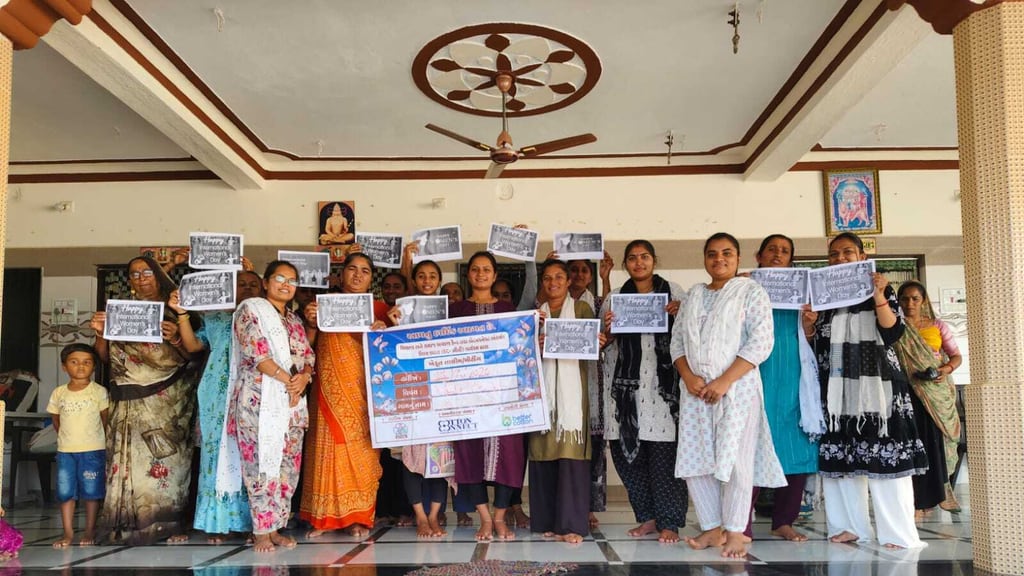 સણોસરીના ગામના હોલમાં આંતરરાષ્ટ્રીય મહિલા દિવસની ઉજવણી દરમિયાન એકસાથે ઊભેલી મહિલાઓ, હાથમાં ‘Happy International Women’s Day’ના સંદેશવાળા કાર્ડ સાથે